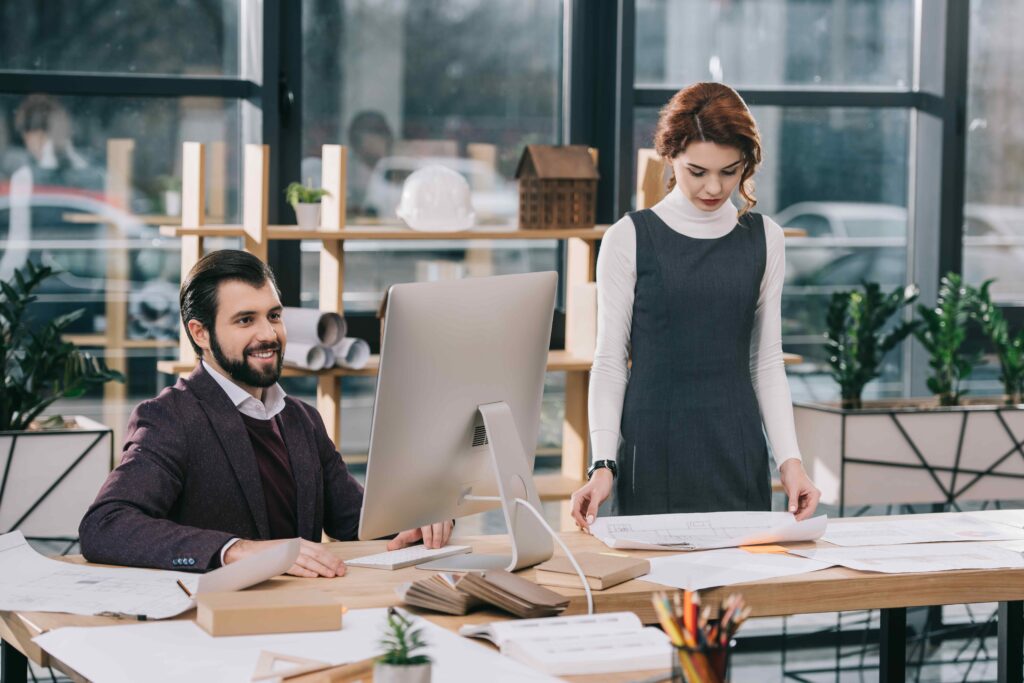 architects working with computer and building plans in modern office