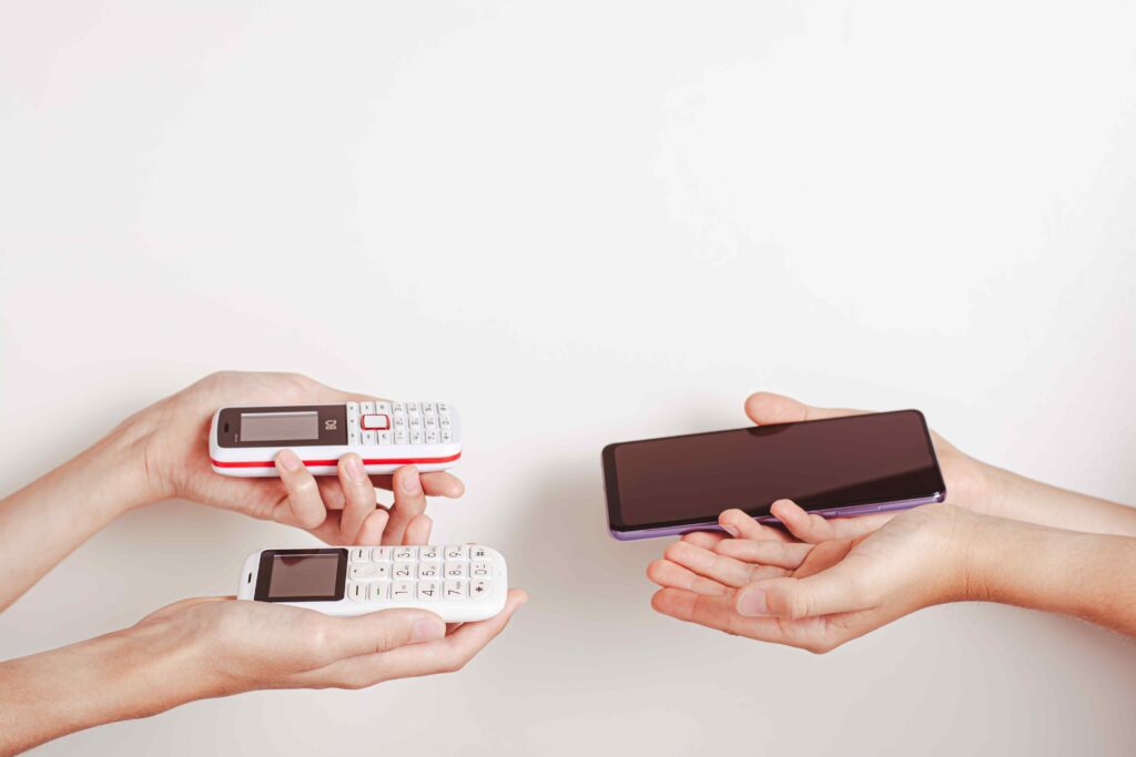 Hands offer an exchange of a push-button phone for a smartphone